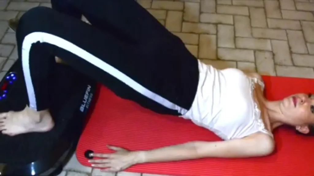sportive faisant un exercice de levée de bassin avec une plateforme vibrante bluefin fitness 3D