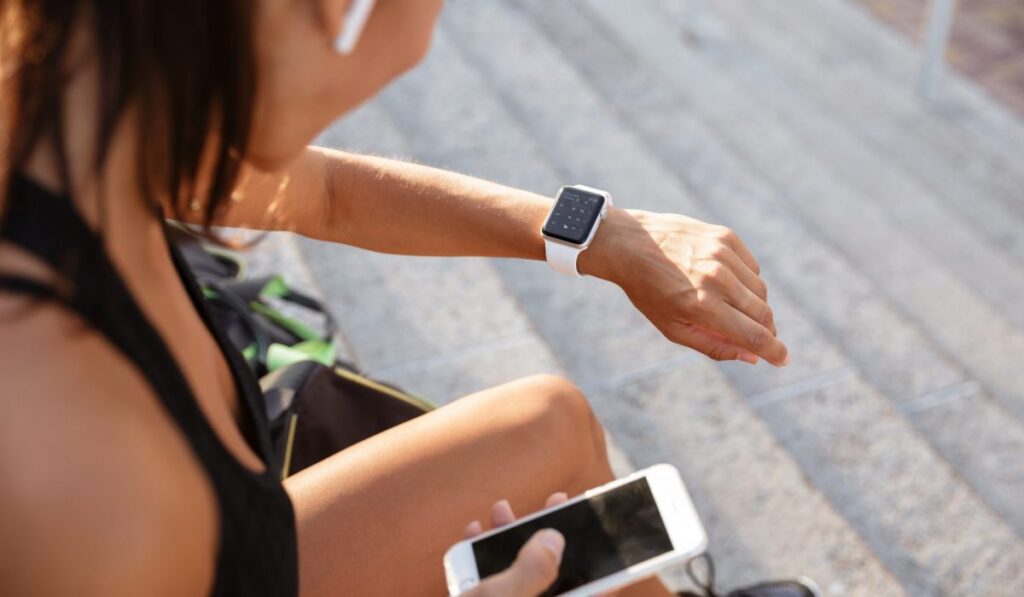 Un sportif en plein effort avec une montre de sport, en train de suivre ses données